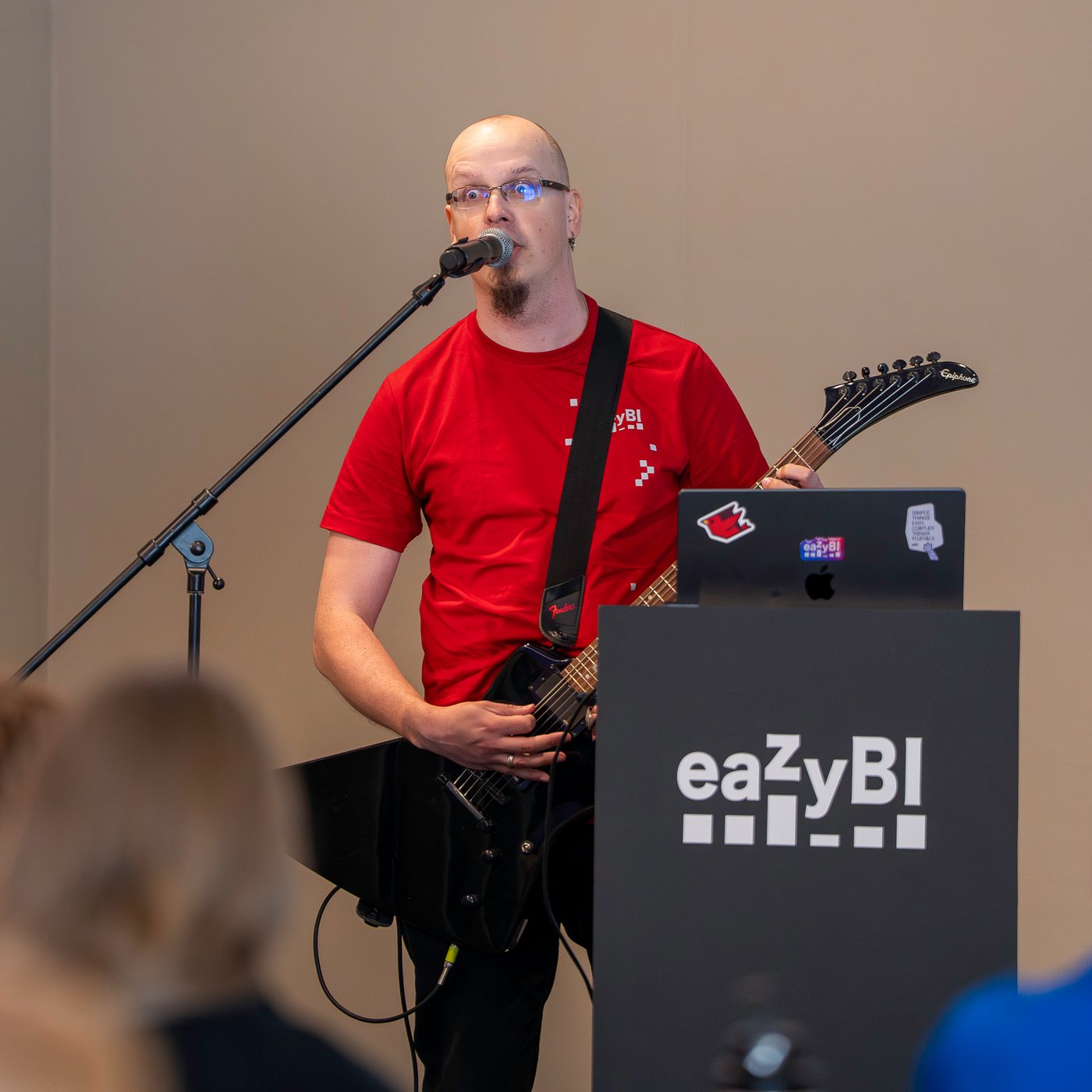 Speaker playing electric guitar and singing at the eazyBI podium