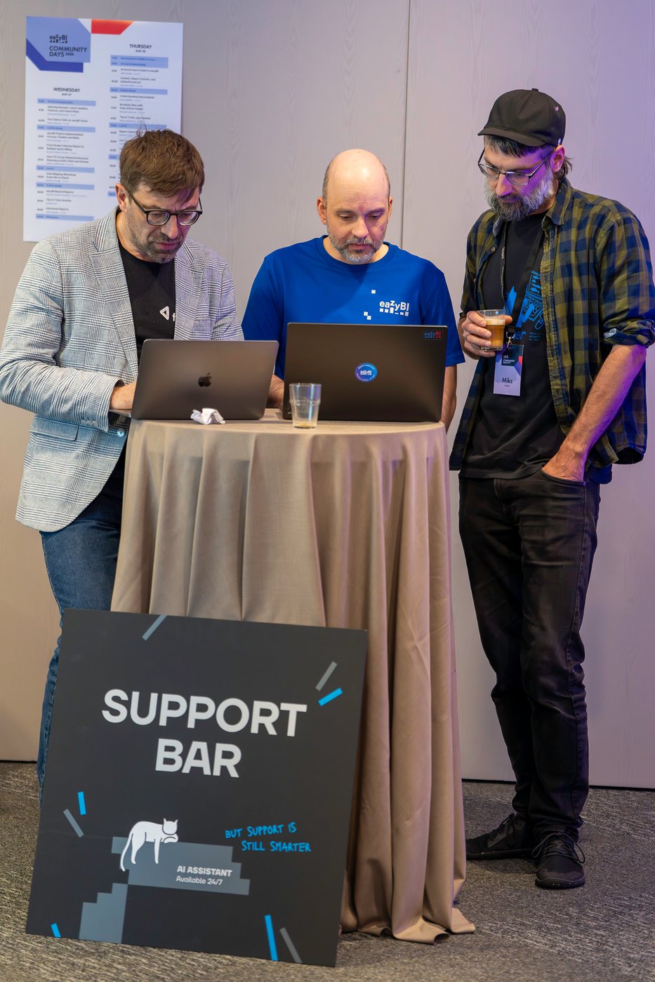 Three attendees working through a question at the Support Bar